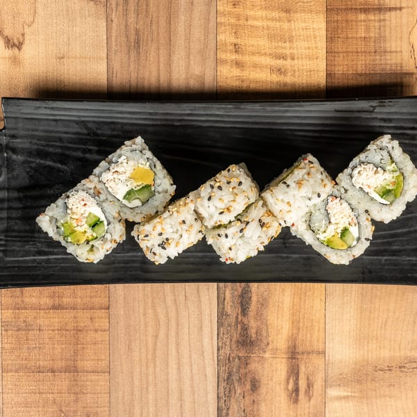 Six pieces of sushi with rice, avocado, and crab meat on a black rectangular plate.