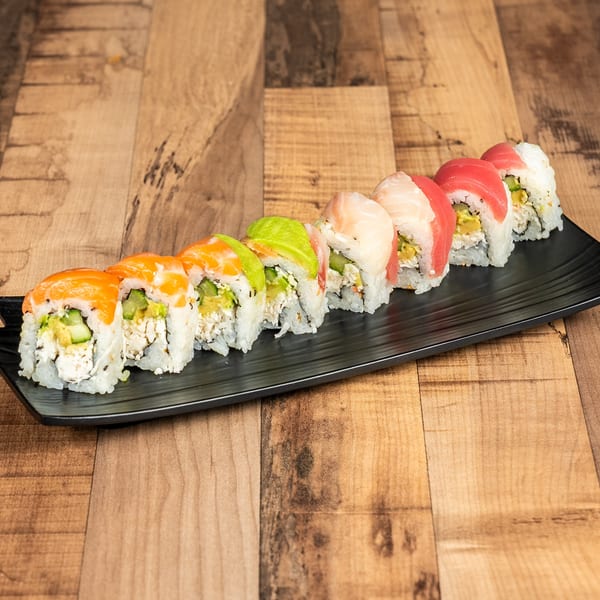 Colorful sushi rolls with salmon, avocado, tuna, and white fish on a black rectangular plate.
